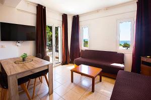 a living room with a couch and a table at Romanos Beach Villas in Romanu