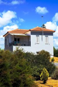 a white house on top of a hill at Romanos Beach Villas in Romanu