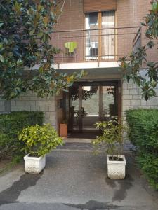 a building with two potted plants in front of it at La Casa dei sapori 8 letti 3 came 1 cucina in Mirandola +6 photos