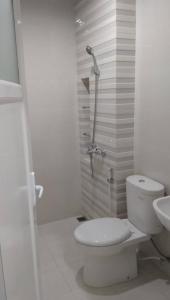 a white bathroom with a toilet and a shower at Keygalaxy in Majalengka