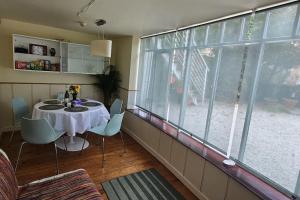 a dining room with a table and a large window at Hideaway Garden Paradise in Dublin +29 photos