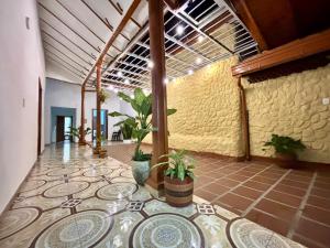 a lobby with a tile floor with plants on it at Casa colonial jacuzzi cerca al parque principal in Santa Fe de Antioquia