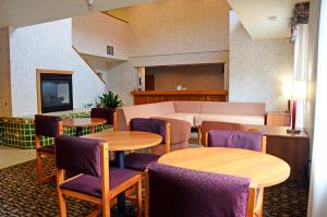 a room with tables and chairs and a couch at Budget Host Inn in Allegan
