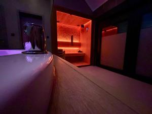 a dark room with a room with a bed and a window at Pause Thermale Suites Deluxe et Spa Privatif in Herstal