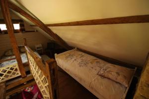 an attic room with a bed and a ladder at Le chant du coucou in Bois Gars