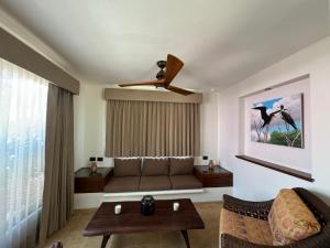 a living room with a couch and a ceiling fan at Hotel Manglares Cabaña Fragata in Celestún