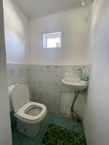 a bathroom with a toilet and a sink at Family Guest House in Cholpon-Ata +42 photos
