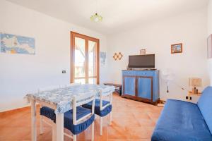 ファヴィニャーナにあるCasa vacanze Villa Raffaelaのテーブルと青いソファのあるリビングルーム