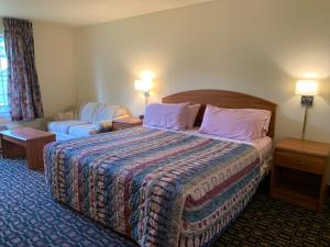 a hotel room with a bed and a couch at Budget Host Inn in Allegan