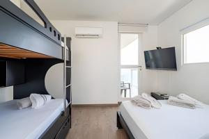 two beds in a room with a flat screen tv at 2 Dormitorios Vista Mar. Piscina y Spa in Gaira +58 photos