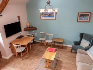 a living room with a tv and a table and chairs at The Grain Store in Abersoch