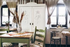 a dining room with a table and chairs and a cabinet at Pájlánd HÁZ -1770- Márok in Márok +55 photos