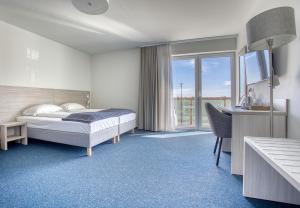 a bedroom with a bed and a desk and a desk at Willa Z Widokiem na Jezioro in Ryn