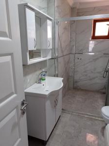 a white bathroom with a sink and a shower at Kuş pansiyon in Kandıra