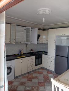 a kitchen with white cabinets and a refrigerator at Kuş pansiyon in Kandıra +8 photos