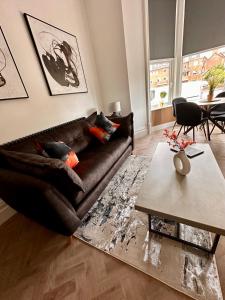a living room with a brown couch and a table at No1,luxury 1 bed apartment in Saint Annes on the Sea +7 photos