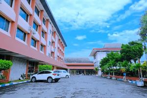 a parking lot in front of a building at Bandung Permai Hotel Jember in Jember