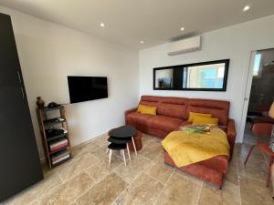 a living room with a couch and a table at Breathtaking Mediterranean Views from Renovated Cosy Nest, Walk to Portissol Beach and Port in Sanary-sur-Mer