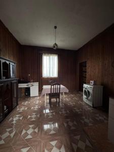 een woonkamer met een tafel en een wasmachine bij Дом Бобоквати in Kobuleti