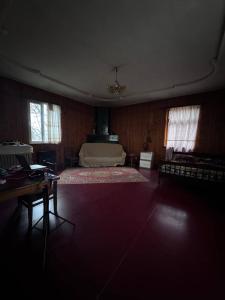 een slaapkamer met een bed, een tafel en ramen bij Дом Бобоквати in Kobuleti +3 foto's