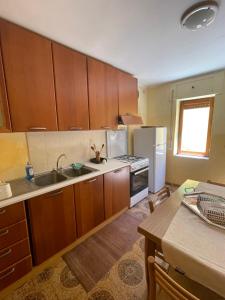 cocina con armarios de madera, fregadero y nevera en Villino indipendente Stella, en Anzio 13 fotos más