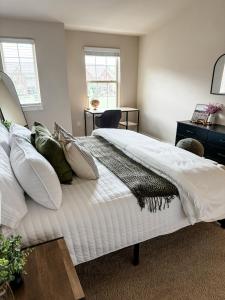 プリマスにあるElegant & Modern Plymouth 3-bed 25-bath Townhomeの白いシーツと枕が備わったベッドのある寝室