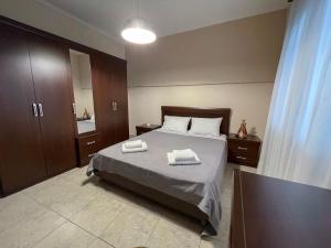 a bedroom with a bed with two towels on it at Aristides Guesthouse in Krinídhes