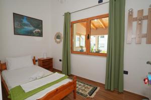 a small bedroom with a bed and a window at The VIEW Rooms and Terrace in Gjirokastër