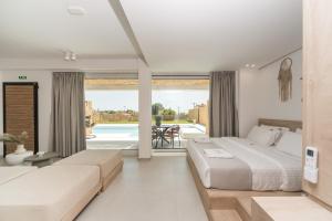 two beds in a bedroom with a view of a pool at Saint John Halkidiki in Nikiti +82 photos