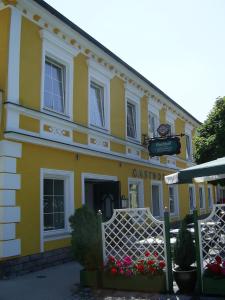 un bâtiment jaune avec un panneau devant lui dans l'établissement Gasthof Grünling, à Wallsee