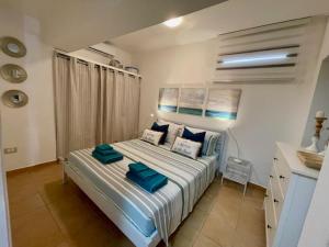 une chambre avec un grand lit avec des oreillers bleus dans l'établissement Casamare Lido di Noto, à Noto Marina