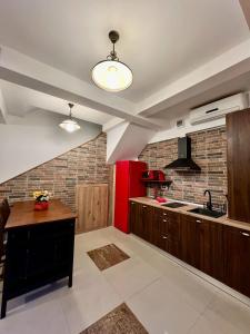 a kitchen with a red refrigerator and wooden cabinets at Marsali Vila in Constanţa