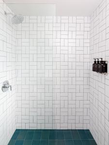 a white tiled shower with a green tile floor at The Outpost Rocky Mountains in Estes Park