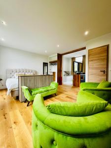 a living room with green chairs and a bed at Hébergement au château 105 in Tinlot