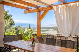 a wooden table and chairs on a balcony with a window at Villa Valentina - Luxurious holiday for 9 people with xxl pool and whirpool in Bribir