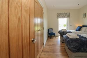 a bedroom with two beds and a door with towels at Bramble Cottage in Blairgowrie