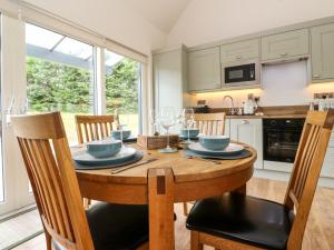 a kitchen and dining room with a wooden table and chairs at Strawberry Cottage in Blairgowrie