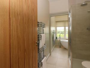 a bathroom with a tub and a toilet and a sink at Strawberry Cottage in Blairgowrie