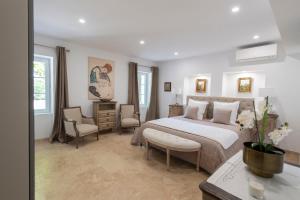 a bedroom with a large bed and chairs in it at La Bastide des Lavandins in Le Thor +89 photos