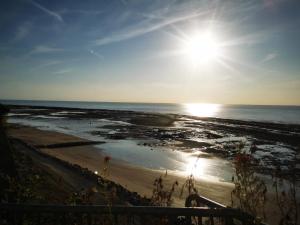 a beach with the sun rising over the ocean at La Crevette in Villerville +8 photos