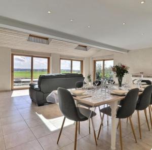 a living room with a table with chairs and a couch at Gîte les goélands in Cherrueix