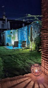 two benches sitting in a yard with a wall at Villarosario in Piles