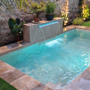 a swimming pool with a fountain in a yard at Villarosario in Piles