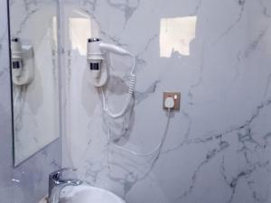 bagno con lavandino e telefono appeso a una parete di اصيل الفاخره المخدومه a Taif