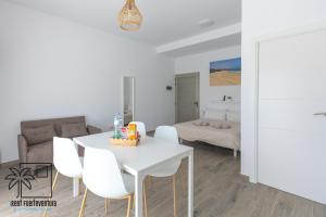 sala de estar con mesa blanca y sillas blancas en Lola Loft 1 Lajares iRent Fuerteventura, en La Oliva