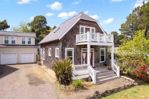 une petite maison en briques avec un porche et un garage dans l'établissement Bella Beach Retreat, à Depoe Bay