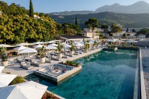 an infinity pool with lounge chairs and umbrellas at a resort at Lazure Hotel & Marina in Herceg-Novi