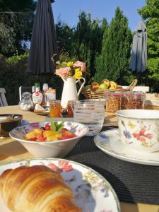 a table with plates of food and a bowl of bread at La Crevette in Villerville