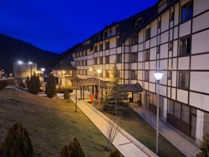 a building at night with a park in front of it at Apartman 22, Brzeće Centar in Mramor
