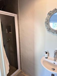 a bathroom with a sink and a shower with a mirror at Studio #2 in East London